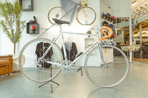 Ein weißes Rennrad mit orangenen Streifen in einem Radladen